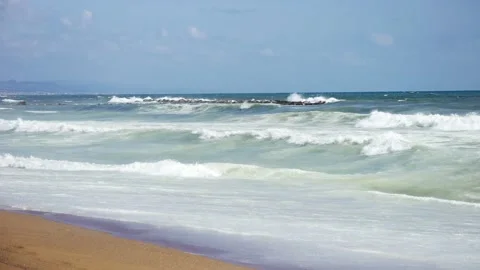 Mild waves on a beach with blue sky - Slow Motion Stock Footage 173767252