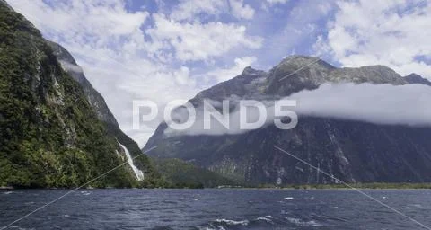 Milford Sound waterfall and cloud around mountains Stock Photos