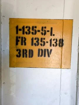 Military acronym text code stencil on wall yellow and white Stock Photos