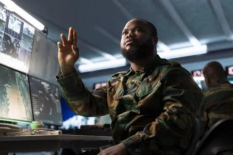 Military analyst examining intel data in army headquarters Stock Photos