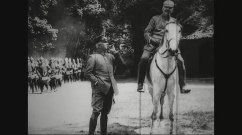 Military band marching past two military officers Stock Footage
