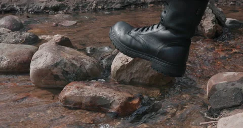 Military boot crosses river Stock Footage