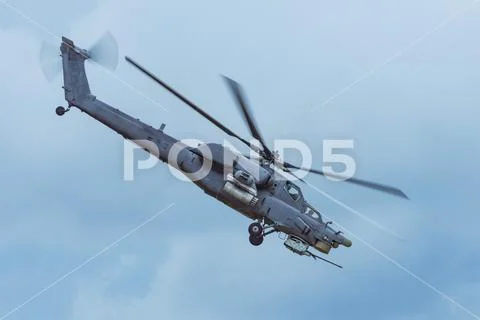 Military combat helicopter flies rapidly turning in the air. Stock Photos