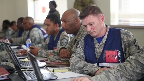 Military deployment processing staff waiting at computers for airmen to arrive Stock Footage 91381420