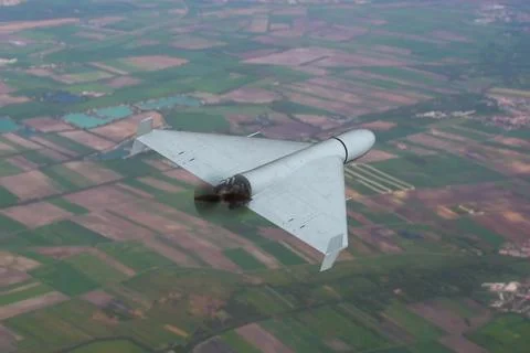 Military drone flying over patchwork farmland in rural aerial surveillance .. Stock-Fotos
