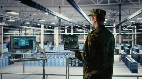 Military engineer in data center tracking satellite coordinates using laptop Stock Footage 314685207