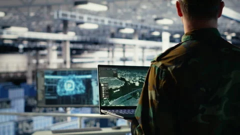 Military engineer in data center tracking satellite coordinates using laptop Stock Footage 314803673