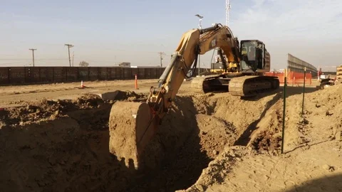 Military excavator digging a large pit in a field Stock Footage 112128149