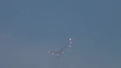 Military fighter jet doing stealth evasive maneuvers, anti missile flares Stock Footage 147569866