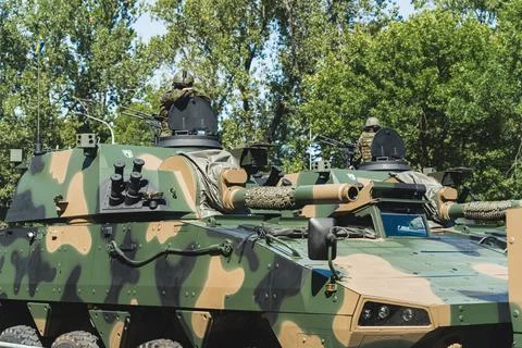 Military forces concept. Two smaller battle tanks with soldiers on top against Stock Photos