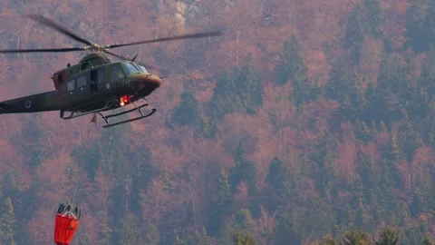 Military helicopter with a specialized empty bucket descending Stock Footage 176466479