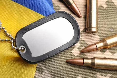 Military ID tag, bullets and Ukrainian flag on pixel camouflage, flat lay Stock Photos