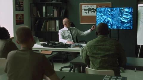 Military Instructor Pointing at Satellite Map on Screen During Class Vídeos de archivo 257793471