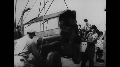 Military jeep being loaded on warship at harbour of south coast Stock Footage