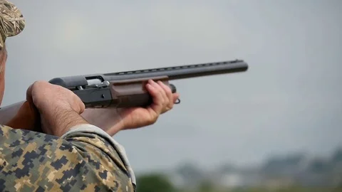 Military man aims, pulls a trigger and shoots from a one barrel shotgun in slo 動画素材 76052825