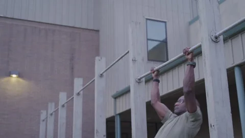 Military Man Outside Doing Pull Ups on a Break From Work Stock Footage 208782921