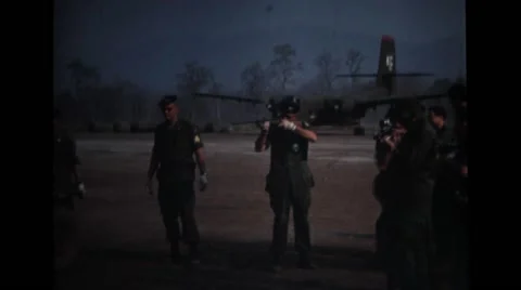 Military man shooting with a rifle and other military men filming Stock Footage