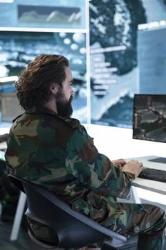 Military operator works at computer workstation in command center Stock Photos