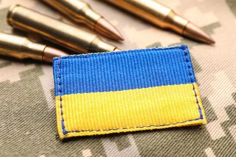 Military patch and bullets on pixel Ukrainian camouflage, closeup Fotos de archivo