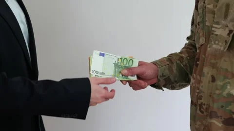 Military person hands stack of euro cash to person in business suit on neutral b Stock Footage 336625643
