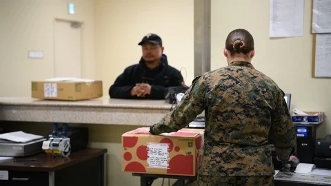 Military postal worker logging parcel on computer Stock-Footage 122210553