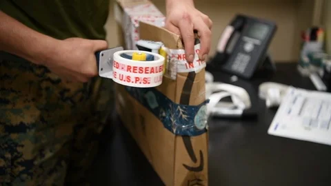 Military postal worker securing parcel with roll of tape 스톡 동영상 122211989