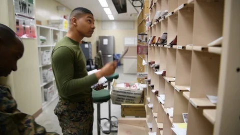 Military postal worker sorting mail into pigeon holes Stock Footage 122213738