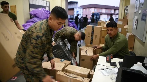 Military postal workers sorting and logging parcels Stockbeeldmateriaal 122211516