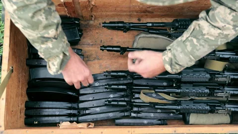 The military puts ammunition in a box. Sorting ammunition and submachine guns in Vídeo Stock 165419527