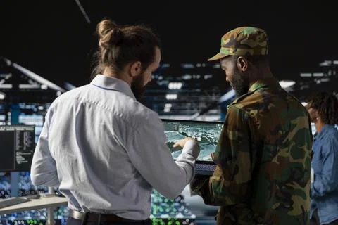 Military server room IT professionals using AI LLM tech on laptop Stock Photos