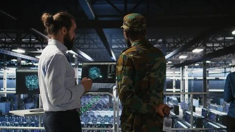 Military server room IT professionals using AI LLM tech on laptop Stock Photos