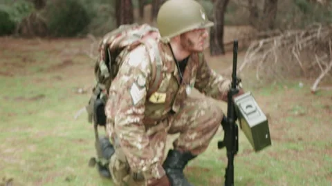 Military soldier bends down and recognizes the terrain, touching it Stock Footage 237635563