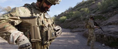 Military soldier browsing map on wearable military tablet in the terrain Stock Footage 97385053