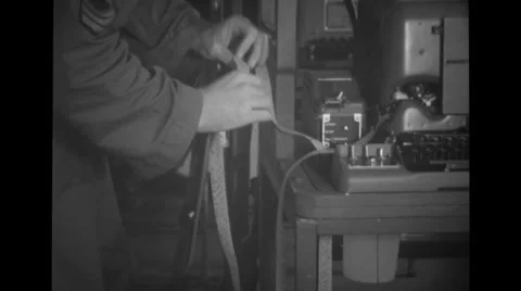 Military soldier checking tape at re-perforator Stock Footage