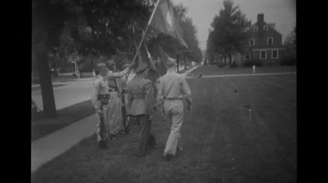 Military soldiers stand in a row holding flags while officer passing by them Stock Footage