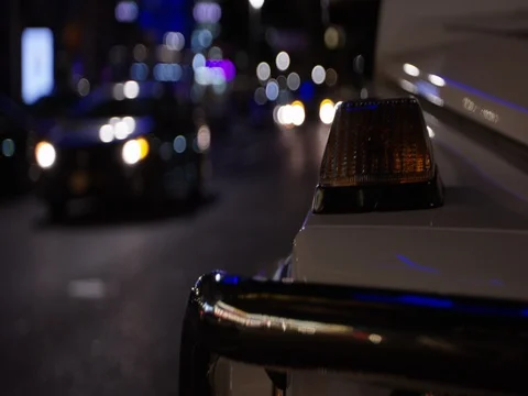 Military SUV parked on street at night - hand held up close Stock Footage