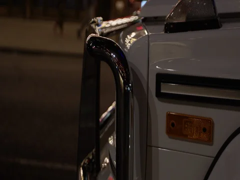 Military SUV parked on street at night - white with chrome brush guard Stock Footage