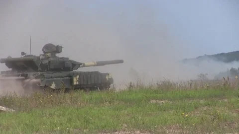 Military tank rides and shoots on the move Stock Footage