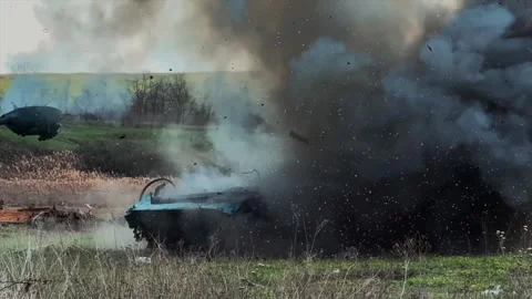 Military tank strikes a target which explodes and scatters debris Stock Footage 313255487