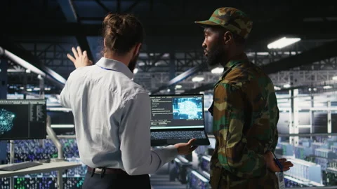 Military technicians in secure data center use laptop to monitor AI systems Stock Footage 310789014