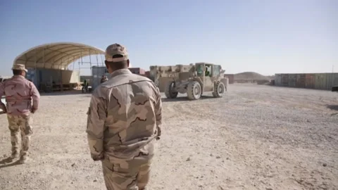 Military telescopic handler transporting pallet of boxes at Al Asad Air Base Stock Footage 168740775