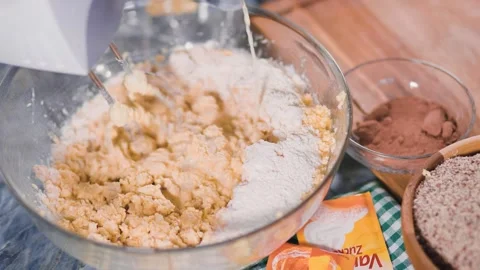 Milk is added to batter in a bowl while ingredients are ready Stock Footage 334346706