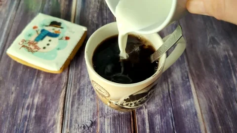 Milk is added to a cup of black coffee Stock Footage 231049481