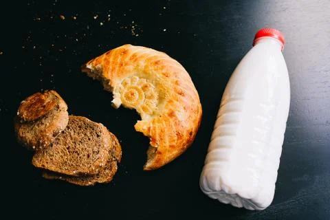 Milk and bread on a black table 스톡 사진