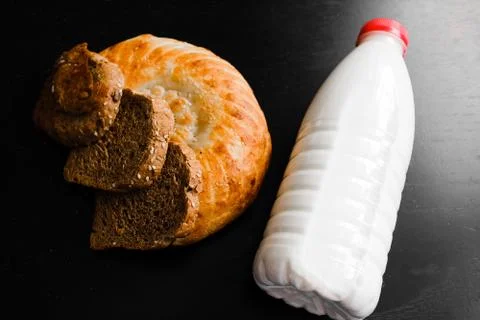Milk and bread on a black table Stock Photos