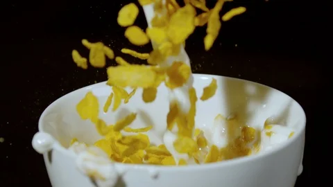 Milk and corn flakes being poured into a bowl, Ultra Slow Motion Stock Footage 86577556