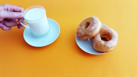 Milk and Donuts in Soft Orange Light- A Cozy Morning Ritual Stock Footage 312808568