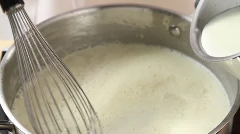 Milk being added to a roux Stock Footage 24649281