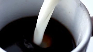 Milk being poured into coffee Vídeos de archivo 85849320