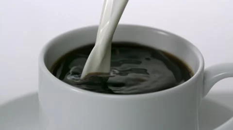 Milk being poured into cup of coffee, Slow Motion Stock Footage 10700786